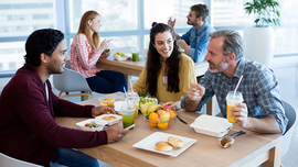Kollegen beim Mittagessen mit gesundem Essen in der Kantine