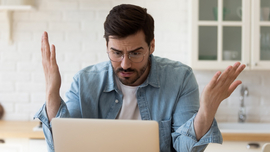 Frustrierter Mann vor einem Laptop