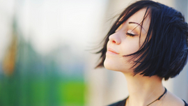 Zufriedene Frau h&auml;lt ihr Gesicht in die Sonne