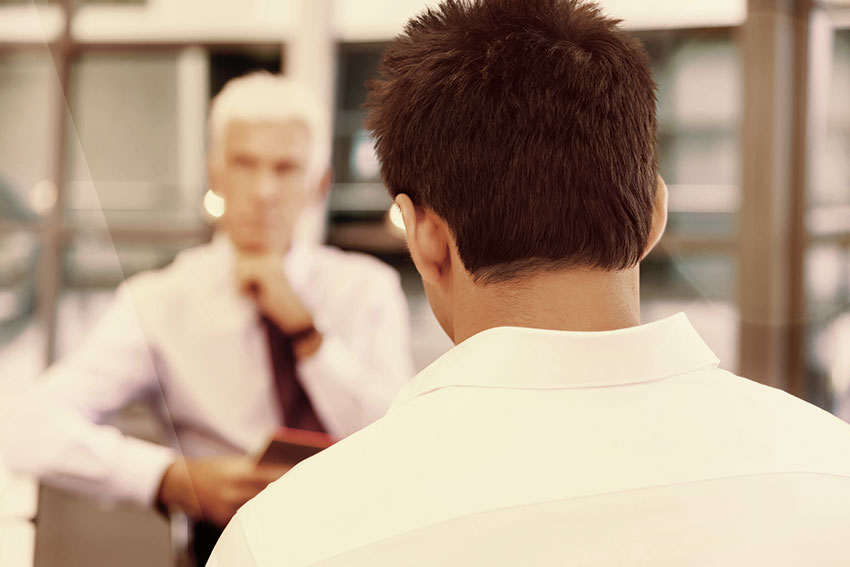 &Auml;lterer Mann sitzt j&uuml;ngerem Mann gegen&uuml;ber