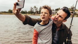 Vater und Sohn machen ein Selfie von sich beim Angeln