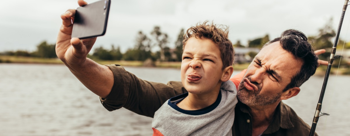 Vater und Sohn machen ein Selfie von sich beim Angeln