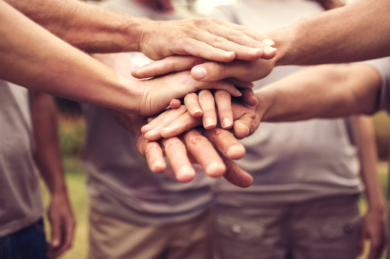 Drei H&auml;ndepaare liegen &uuml;bereinander und vermitteln Vertrauen