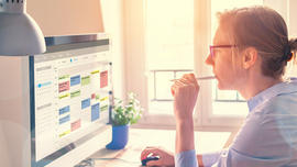 Frau plant Arbeitszeiten am Computer