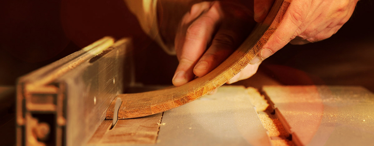 Hände biegen ein eingespanntes Holz 