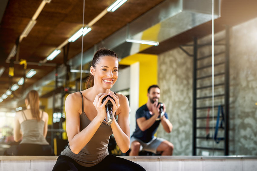 Frau und Mann beim Sport in einem Fitnessraum