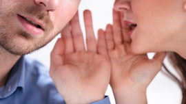 Frau und Mann in Nahaufnahme, die sich etwas zufl&uuml;stern