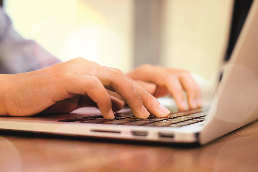 Zwei H&auml;nden zu sehen, die am Laptop arbeiten.