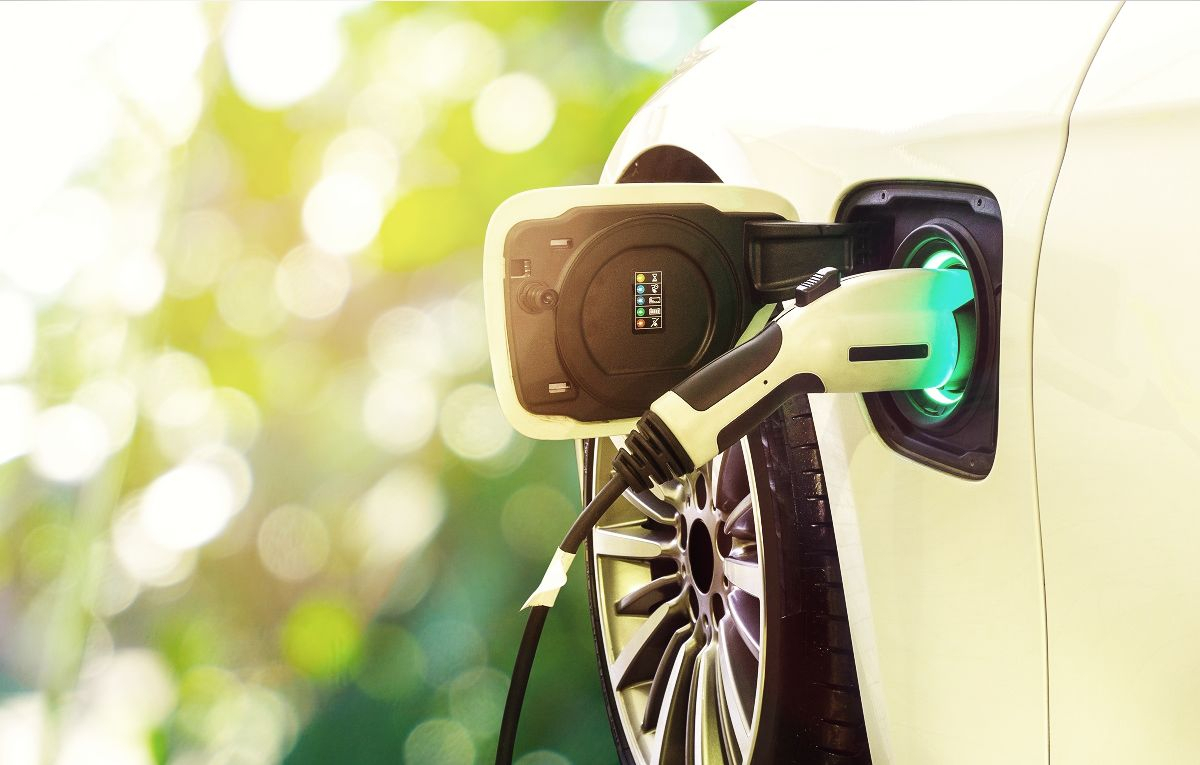 Teilansicht eines E-Fahrzeuges, das gerade aufgeladen wird.