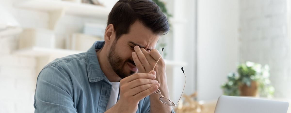 Mann vor dem PC reibt sich die Augen