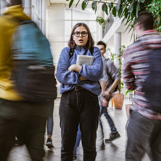 Eine Studentin mit Brille schaut &auml;ngstlich und schockiert.