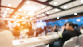 BKK VBU Seminare Service-Tools: Verschwommenes Bild eines Konferenzsaals mit Teilnehmern von hinten