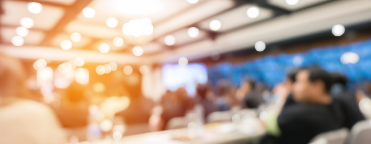 BKK VBU Seminare Service-Tools: Verschwommenes Bild eines Konferenzsaals mit Teilnehmern von hinten
