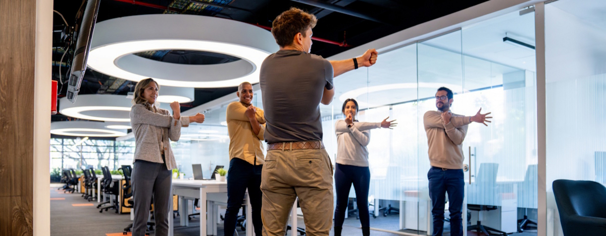 Personen im B&uuml;ro machen Dehn&uuml;bungen