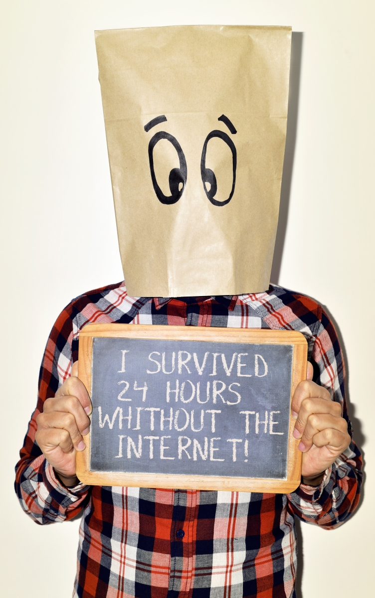 Ein mit einer Papiert&uuml;te vermummter Mann h&auml;lt ein Schild in der Hand, auf dem steht, dass er seit 24 Stunden ohne Internet &uuml;berlebt hat.