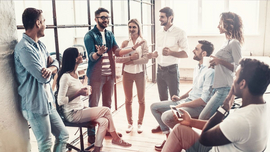 Team aus Kollegen und Kolleginnen steht zusammen und diskutiert