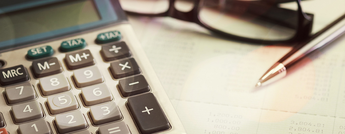 Nahaufnahme mit Taschenrechner, Brille und Kugelschreiber